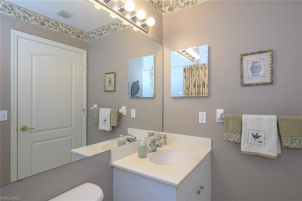8640 Cedar Hammock Circle, Unit 523 Naples, FL 34112 - Photo 20 of 29 a bathroom with a sink a mirror and a toilet
