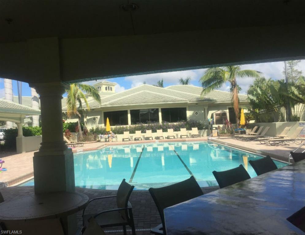 8640 Cedar Hammock Circle, Unit 523 Naples, FL 34112 - Photo 27 of 29 a view of a patio with table and chairs under an umbrella