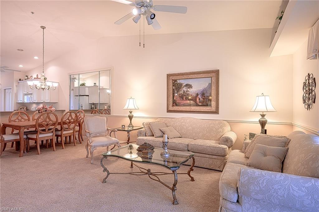 8640 Cedar Hammock Circle, Unit 523 Naples, FL 34112 - Photo 5 of 29 a living room with furniture and a chandelier