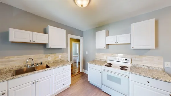 a kitchen with cabinets appliances a sink and a counter space