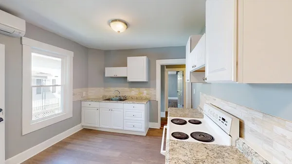 a kitchen with a cabinets a sink a window and stainless steel appliances