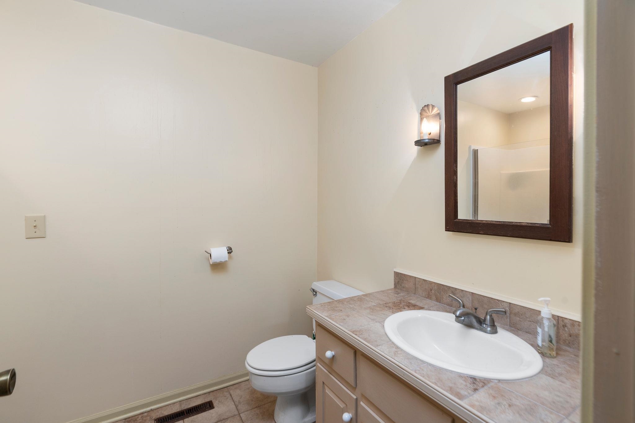 129 Shemariah Road Middlebrook, VA 24459 - Photo 37 of 75 a bathroom with a granite countertop sink toilet and mirror