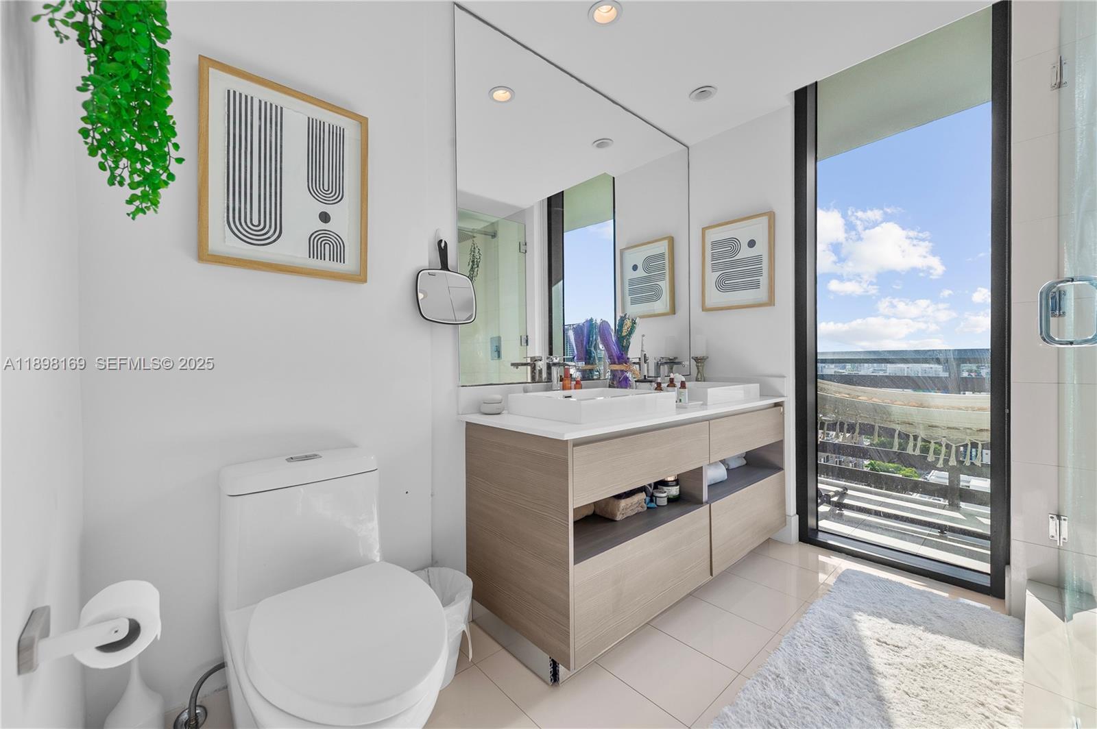 460 Northeast 28th Street, Unit 1901 Miami, FL 33137 - Photo 4 of 34 a spacious bathroom with a toilet a sink and a mirror