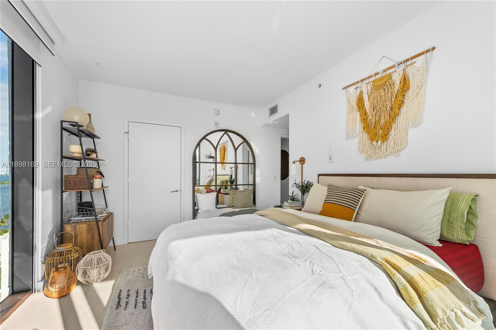 460 Northeast 28th Street, Unit 1901 Miami, FL 33137 - Photo 8 of 34 a bed sitting in a bedroom next to a book shelf