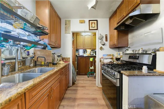 a kitchen with stainless steel appliances granite countertop a sink a stove and a refrigerator
