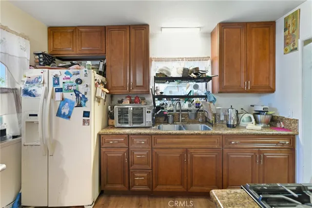 a kitchen with stainless steel appliances granite countertop a refrigerator and a stove top oven