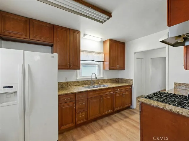 a kitchen with stainless steel appliances granite countertop a refrigerator and a sink