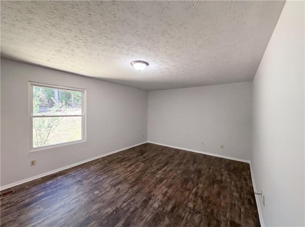 6830 Earlhurst Road Atlanta, GA 30349 - Photo 14 of 27 an empty room with wooden floor and windows