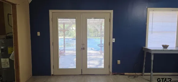 a view of empty room with wooden floor and entryway