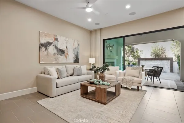 a living room with furniture potted plant and a large window