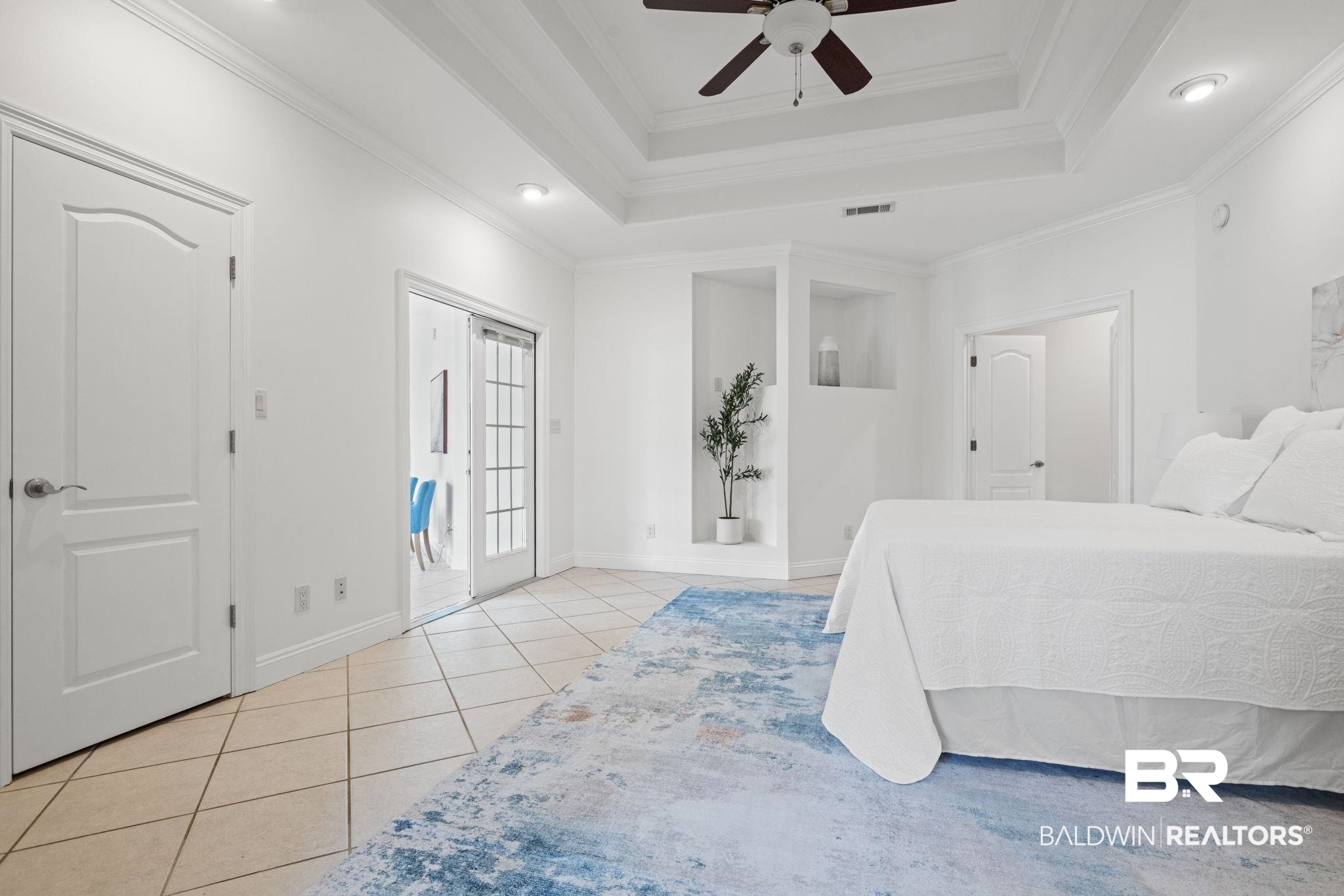 29634 St George Street Daphne, AL 36526 - Photo 26 of 47 Bedroom with a tray ceiling, ornamental molding, light tile patterned flooring, and ceiling fan