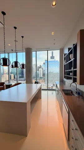 a large kitchen with kitchen island a large window in it