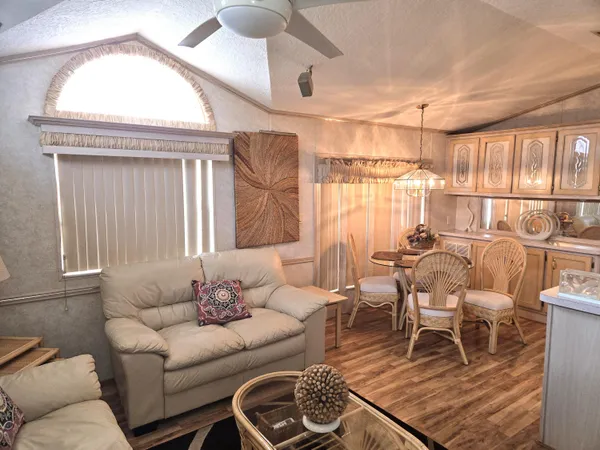 a living room with furniture a large window and chandelier