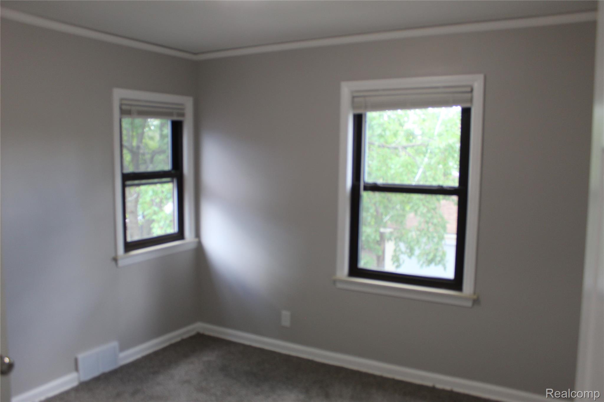 5543 Balfour Road Detroit, MI 48224 - Photo 40 of 54 Room featuring dual windows with white trim, light gray painted walls, crown molding, and gray textured carpeting