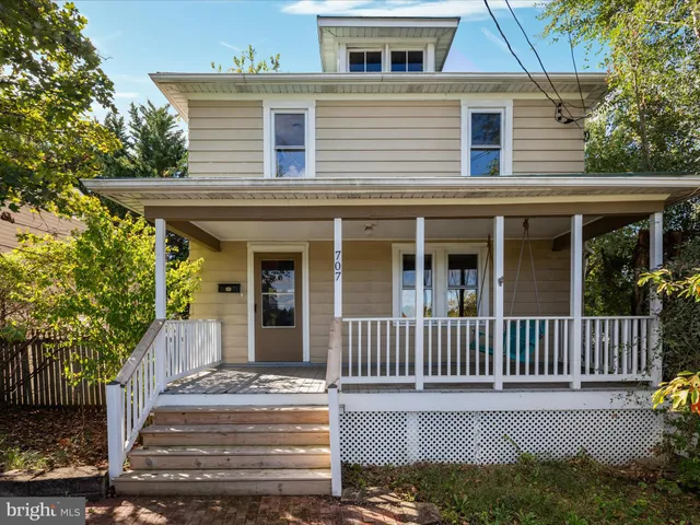 a view of a house with a small yard and wooden fence