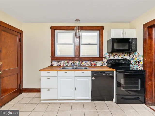 a large kitchen with a window and a refrigerator