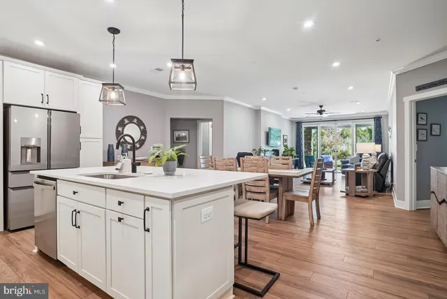 a large kitchen with kitchen island a island a stove a sink a center island and a wooden floor