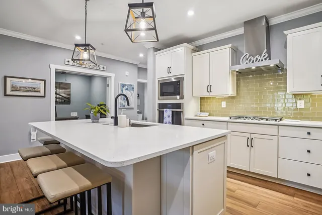 a view of a dining room and livingroom with furniture wooden floor a chandelier