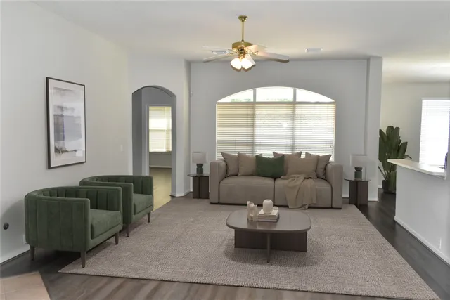 a living room with furniture and a large mirror next to a window