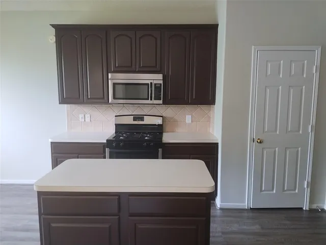a kitchen with a sink a microwave and cabinets