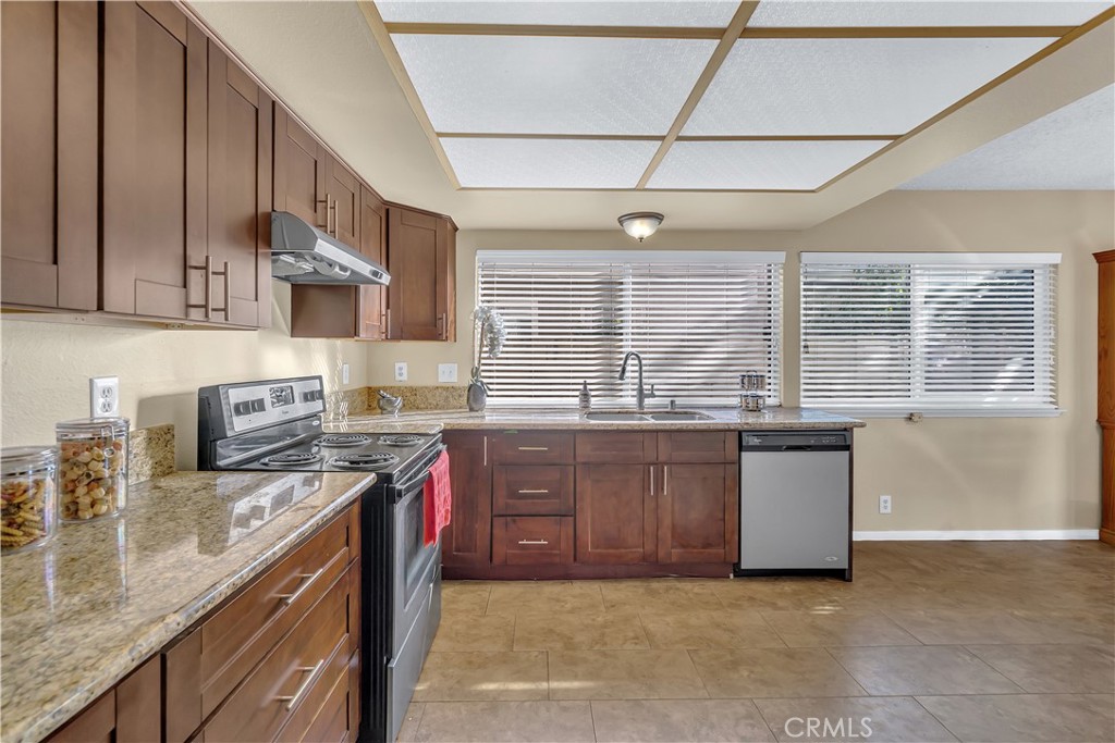 4422 East Silverleaf Avenue Orange, CA 92869 - Photo 9 of 27 a kitchen with stainless steel appliances granite countertop a sink a stove and a wooden cabinets