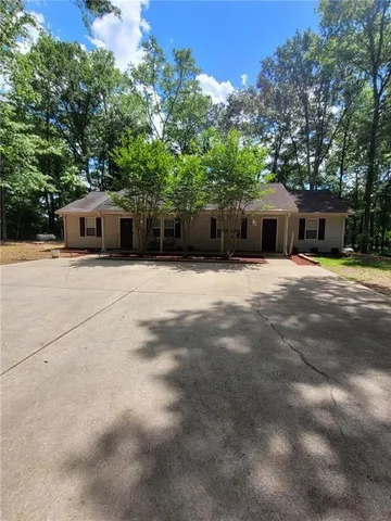 a front view of a house with yard and trees