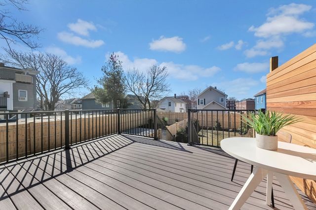 a balcony with wooden floor table and chairs