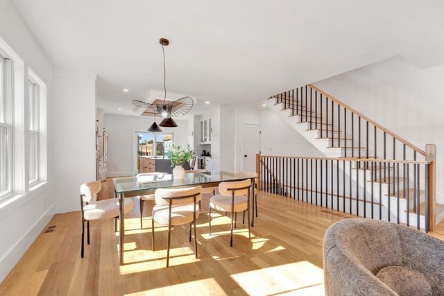 a dining room with furniture a chandelier and wooden floor