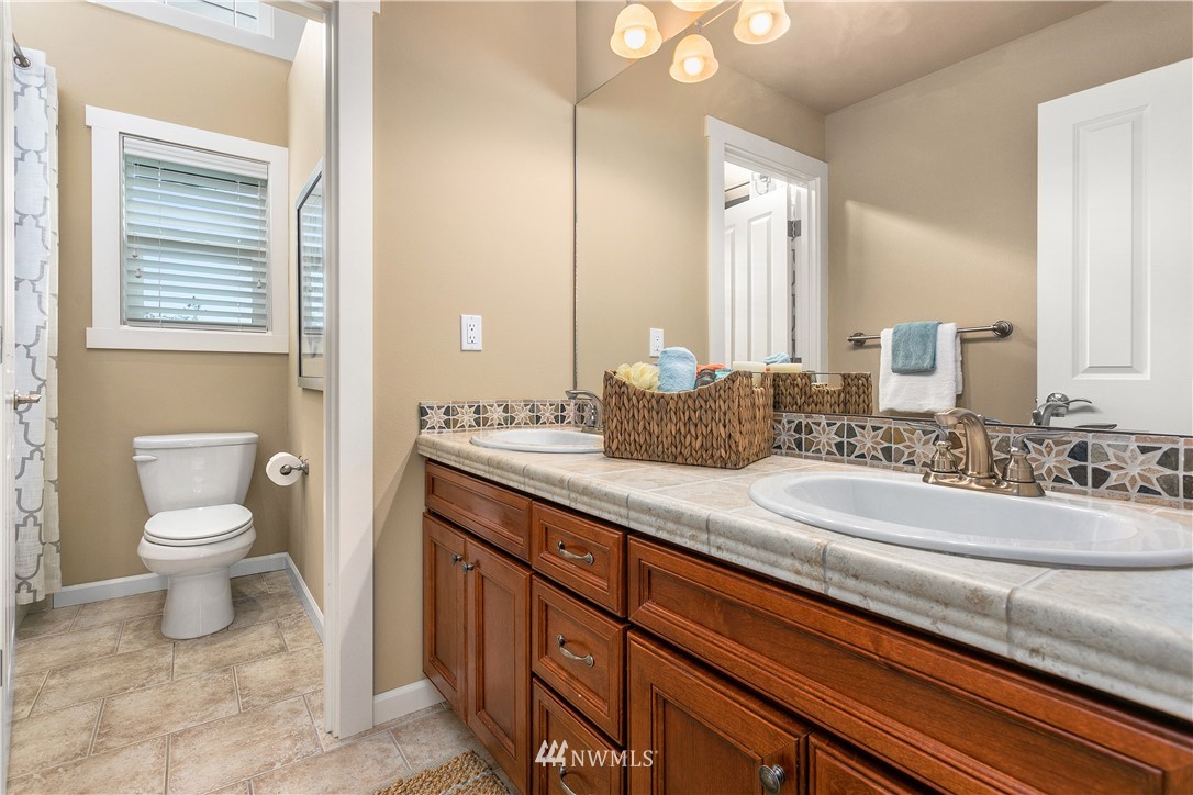 110 N 50th Street Seattle, WA 98103 - Photo 21 of 25 a bathroom with a granite countertop sink mirror and toilet