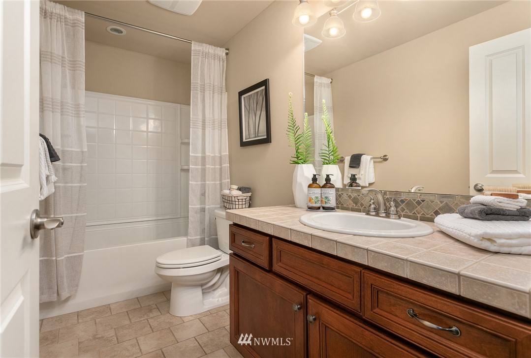 110 N 50th Street Seattle, WA 98103 - Photo 23 of 25 a bathroom with a granite countertop sink toilet and shower