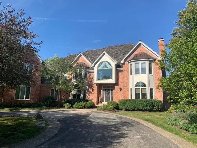 a front view of a residential houses with yard and green space