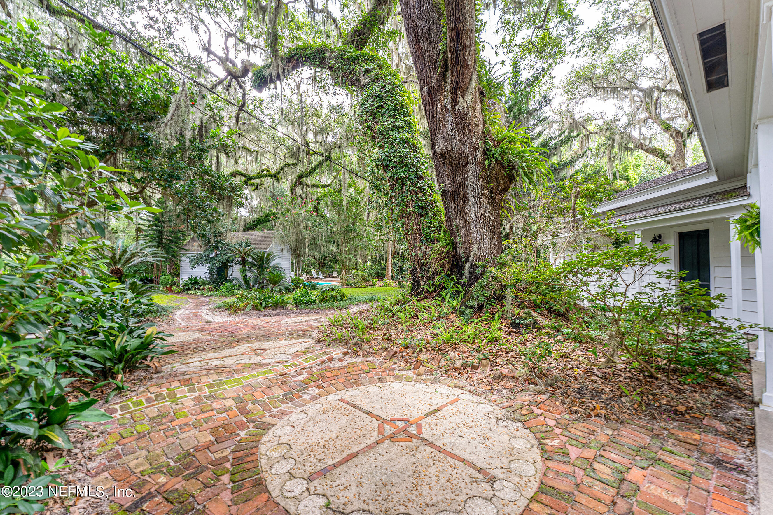 6975 Old Church Road Fleming Island, FL 32003 - Photo 37 of 53 a pathway of a house with lots of plants and large trees