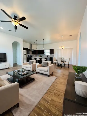 a view of kitchen and empty room with wooden floor