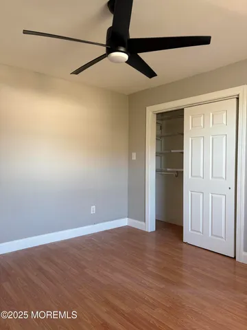 a view of a livingroom with wooden floor and a ceiling fan
