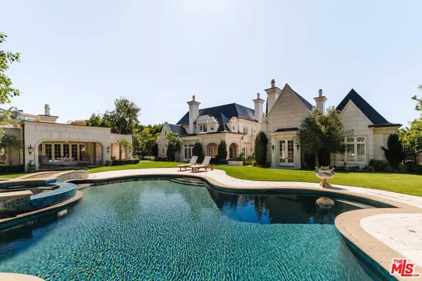 a view of a swimming pool with lawn chairs and a table