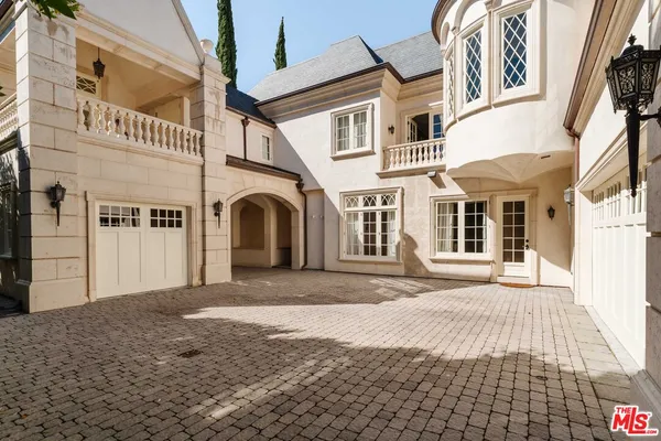 a view of a backyard with potted plants and large trees