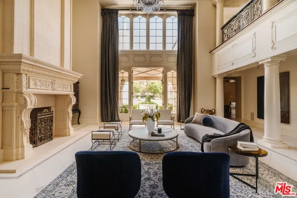 a living room with fireplace furniture and a floor to ceiling window