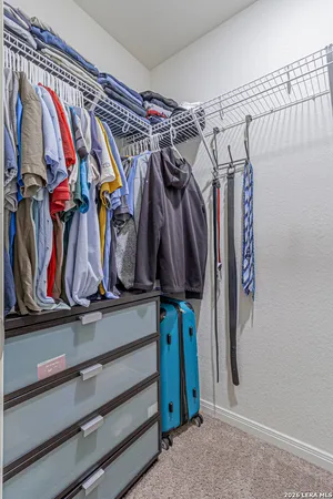 a view of walk in closet with clothes