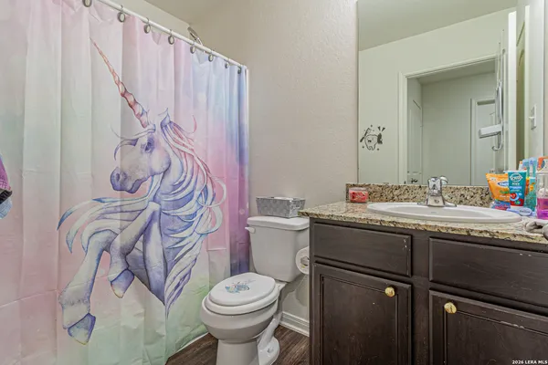 a bathroom with a granite countertop sink and a toilet