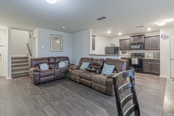 a living room with furniture and a wooden floor