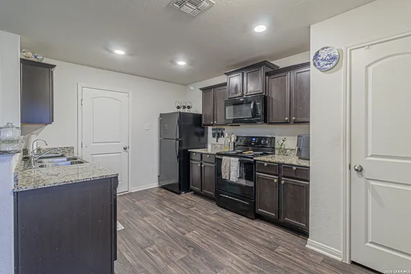 a kitchen with stainless steel appliances granite countertop a refrigerator a stove top oven a sink and dishwasher