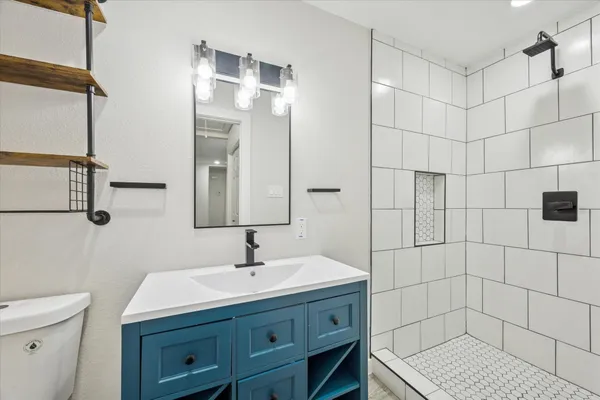 a bathroom with a sink a toilet and shower