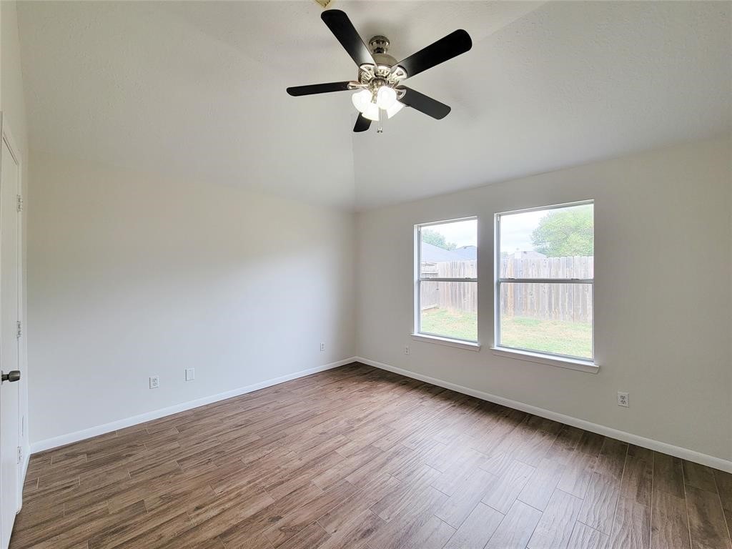 19331 River Bottom Road Katy, TX 77449 - Photo 10 of 23 wooden floor in an empty room with a window