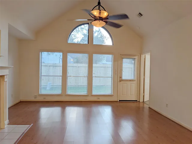 a view of wooden floor and a chandelier fan in a room