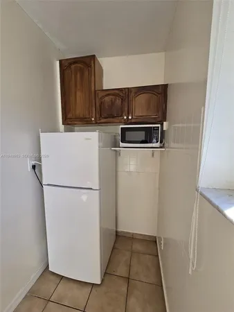 a white refrigerator freezer and a stove sitting inside of a kitchen