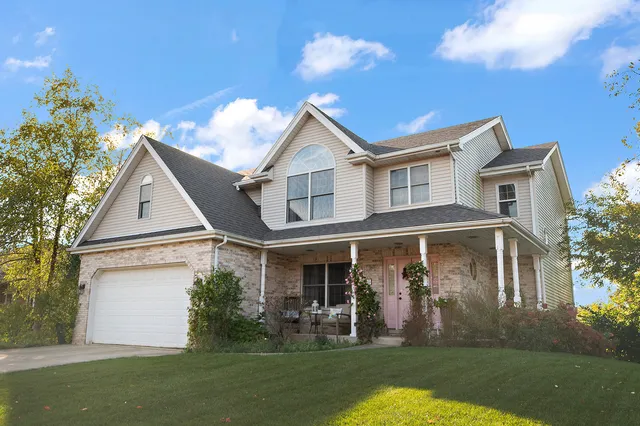 a view of a white house next to a yard with big trees