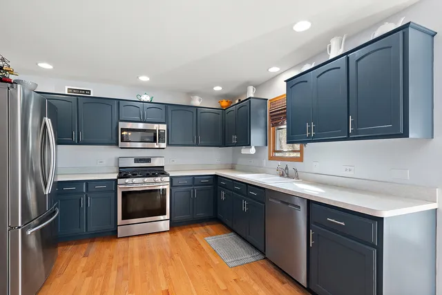 a kitchen with stainless steel appliances granite countertop a sink stove microwave and refrigerator