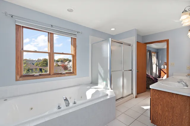 a spacious bathroom with a tub sink and mirror