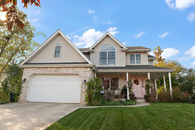 a front view of a house with a yard and trees