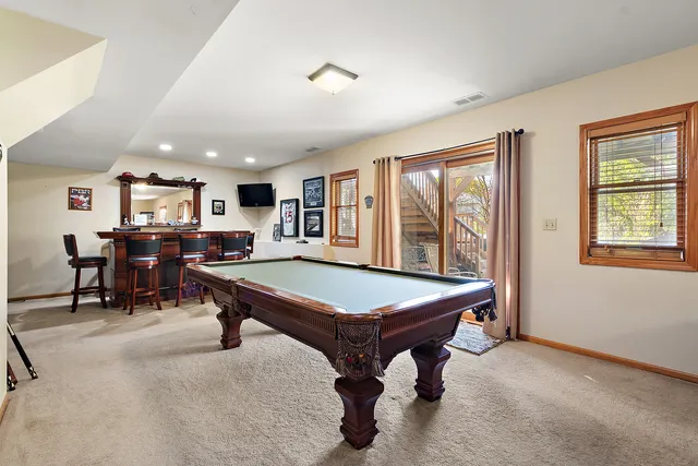 a room with furniture pool table and windows